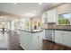 Open-concept kitchen features white cabinets, dark countertops, and stainless steel appliances at 6665 Flagstone Ct # 918, Cumming, GA 30028