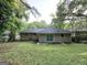 View of the home's backyard featuring a covered patio and large sliding glass doors at 2644 Connally Dr, East Point, GA 30344