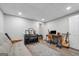 Finished basement with vinyl floors, a futon, piano, desk, and guitar at 1535 Smoke Hill Dr, Hoschton, GA 30548
