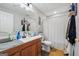 Bathroom with a wood cabinet vanity, toilet, mirror and updated lighting at 1535 Smoke Hill Dr, Hoschton, GA 30548