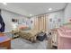 Basement bedroom includes a queen bed, neutral paint, artwork, and a crib for baby at 1535 Smoke Hill Dr, Hoschton, GA 30548