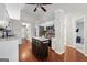 Well-lit kitchen with white cabinets, stainless steel appliances, island and hardwood floors at 1535 Smoke Hill Dr, Hoschton, GA 30548