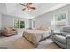 Comfortable bedroom with a ceiling fan, natural light, and carpeted floors at 1535 Smoke Hill Dr, Hoschton, GA 30548