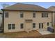 Expansive backyard with a beige two-story home and a small concrete patio at 2126 Roberts View Trl, Buford, GA 30519