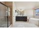 Bathroom featuring walk-in shower, soaking tub, and double vanity with dark cabinets at 2126 Roberts View Trl, Buford, GA 30519