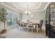 A dining room with a tray ceiling, gray walls, and a cabinet at 2126 Roberts View Trl, Buford, GA 30519
