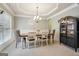 A dining room with a tray ceiling, gray walls, and a cabinet at 2126 Roberts View Trl, Buford, GA 30519