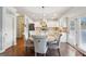 An open-concept kitchen and dining area boasts white cabinets, stainless steel appliances, and hardwood floors at 2126 Roberts View Trl, Buford, GA 30519