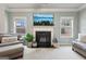 Cozy living room with a fireplace, large windows offering plenty of natural light at 2126 Roberts View Trl, Buford, GA 30519