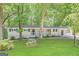 Charming ranch home with a covered front porch surrounded by a lush green lawn and mature trees at 4329 Parkview Dr, Lithia Springs, GA 30122