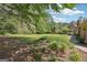 Spacious partially wooded backyard with landscaped garden beds and view of the brick house at 109 Old Virginia Cir, Jonesboro, GA 30236