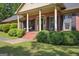 Charming front porch featuring classic columns, black shutters, and meticulously manicured landscaping at 109 Old Virginia Cir, Jonesboro, GA 30236