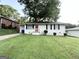 Classic white home featuring a well-kept lawn, brick accents, and a welcoming front porch at 70 Macon Se Pl, Atlanta, GA 30354