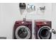 Laundry room features red, front-loading washer and dryer with a storage shelf above at 469 Ralph Still, Dacula, GA 30019