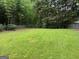 Spacious backyard featuring lush green grass and mature trees, perfect for outdoor activities at 7562 Asbury Manor, Lithonia, GA 30058
