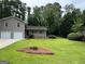 Charming two-story home with a well-manicured lawn, mature trees, and a stone accented porch at 7562 Asbury Manor, Lithonia, GA 30058