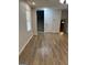 An empty living room with light gray walls, a staircase, modern lighting, and laminate flooring at 7562 Asbury Manor, Lithonia, GA 30058