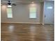 Spacious living room with wood flooring, bright windows, and a modern front door at 7562 Asbury Manor, Lithonia, GA 30058