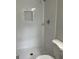 Bright, clean shower area with white tiled walls and a recessed shelf for toiletries at 7562 Asbury Manor, Lithonia, GA 30058
