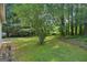 Backyard with lush greenery, landscaping and mossy grass at 686 Shore Ln, Lithonia, GA 30058