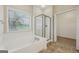 Bathroom featuring a soaking tub, glass shower, tile floors, and natural light at 686 Shore Ln, Lithonia, GA 30058