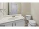 Bathroom featuring a white vanity, a sink, a toilet, a mirror, and neutral wall color at 686 Shore Ln, Lithonia, GA 30058