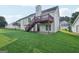 Spacious backyard with a deck featuring stairs, lush lawn, and mature trees at 4738 Golod Way, Lithonia, GA 30038