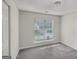 Bright bedroom featuring a large window with blinds and neutral-toned walls and carpet at 4738 Golod Way, Lithonia, GA 30038