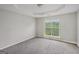 Neutral bedroom with a tray ceiling, large window, and neutral carpet at 4738 Golod Way, Lithonia, GA 30038