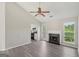 Spacious living room with a fireplace, ceiling fan, and neutral walls adjoining a modern kitchen at 4738 Golod Way, Lithonia, GA 30038