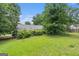 View of the grassy backyard with mature trees and greenery at 4705 Ernest Dr, Forest Park, GA 30297