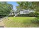 Exterior view of a charming single-story house surrounded by lush greenery and a vibrant lawn at 4705 Ernest Dr, Forest Park, GA 30297