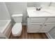 Bathroom features white vanity and toilet, dark fixtures, and wood-look flooring at 6005 Crowley Dr, Douglasville, GA 30135