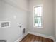 Neutral laundry room complete with wood floors, shelving, and a window for natural light at 6005 Crowley Dr, Douglasville, GA 30135