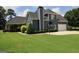 Back exterior with large windows, basketball hoop, well-maintained lawn, and covered patio with ceiling fans at 9 Warrior Way, Sharpsburg, GA 30277