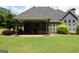 Exterior view showcasing the home's backyard with an inviting covered patio, lawn, and ample natural light at 9 Warrior Way, Sharpsburg, GA 30277