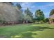 Vast backyard with mature trees and partially obscured views of the house's patio and outdoor seating at 9 Warrior Way, Sharpsburg, GA 30277