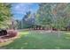 The expansive backyard boasts mature trees, lush green grass, and a covered patio area at 9 Warrior Way, Sharpsburg, GA 30277