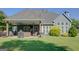 Spacious backyard with a covered patio featuring a grill, lounge area, and mounted television at 9 Warrior Way, Sharpsburg, GA 30277