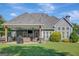 Spacious backyard with a covered patio featuring a grill, lounge area, and mounted television at 9 Warrior Way, Sharpsburg, GA 30277