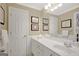Bathroom with double doors, clean countertops, decorative mirror, and white wainscoting at 9 Warrior Way, Sharpsburg, GA 30277