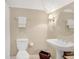 Neutral bathroom featuring a pedestal sink, round mirror, and classic white toilet at 9 Warrior Way, Sharpsburg, GA 30277