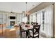 Sunlit dining area featuring hardwood floors, decorative chandelier, and open to living area at 9 Warrior Way, Sharpsburg, GA 30277