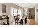 Sunlit dining room with decorative chandelier, light walls and hardwood floors at 9 Warrior Way, Sharpsburg, GA 30277