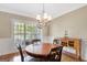 Cozy dining room featuring a chandelier, natural light, hardwood floors and wainscoting at 9 Warrior Way, Sharpsburg, GA 30277