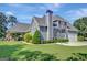 Charming home with a covered patio, lush landscaping, a basketball hoop and an attached garage at 9 Warrior Way, Sharpsburg, GA 30277