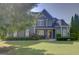 Beautiful two-story home with blue siding, lush lawn, and manicured landscaping creating charming curb appeal at 9 Warrior Way, Sharpsburg, GA 30277
