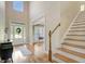 Inviting foyer with natural light, hardwood floors, staircase and stylish entry door at 9 Warrior Way, Sharpsburg, GA 30277
