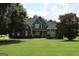 Charming two-story home features a manicured lawn and inviting facade with trees, situated on a landscaped lot at 9 Warrior Way, Sharpsburg, GA 30277