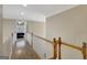 Bright hallway with wood floors, white walls and trim, and oak handrail overlooking open bedroom at 9 Warrior Way, Sharpsburg, GA 30277